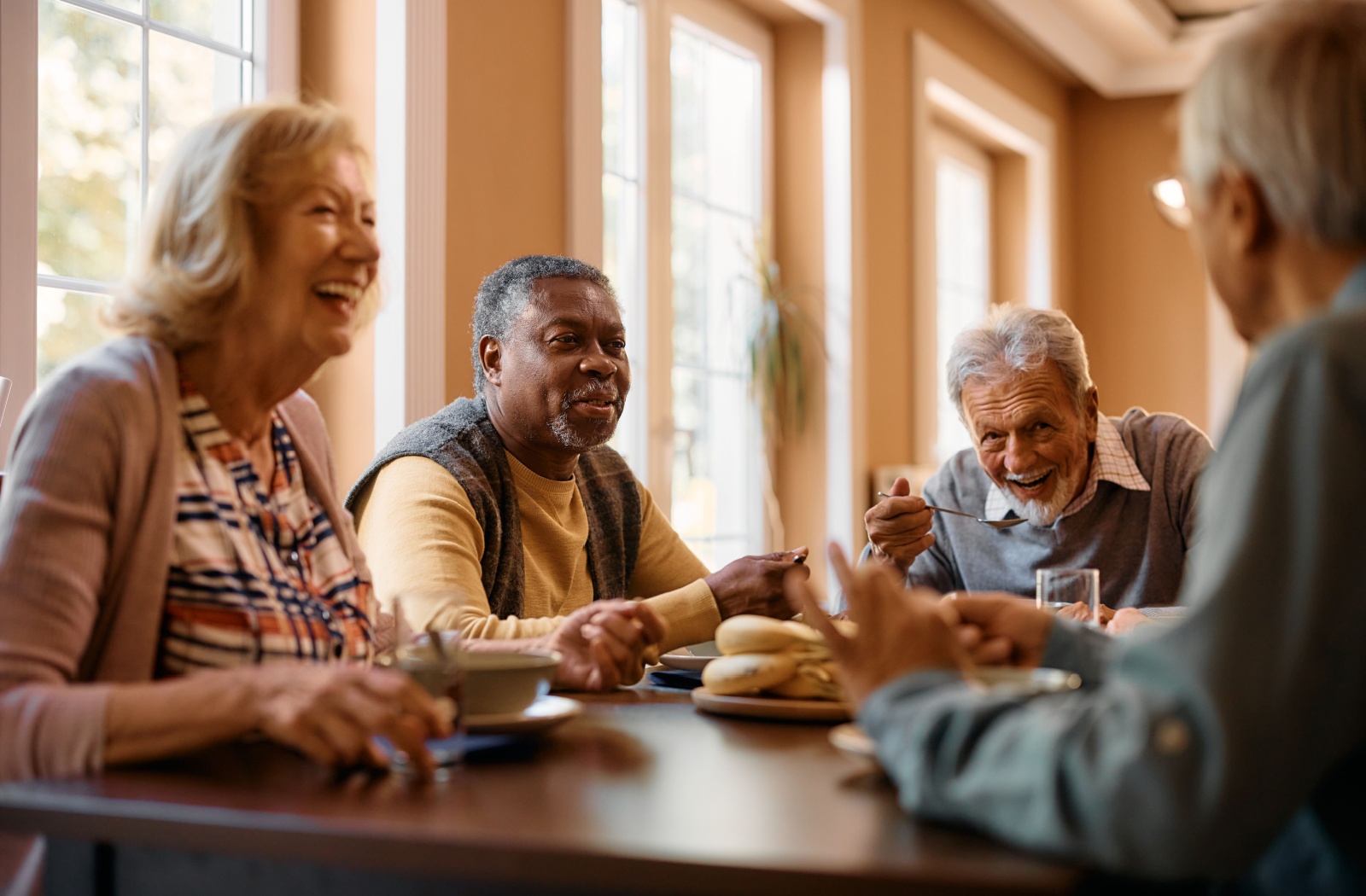 Seniors in assisted living eating together.