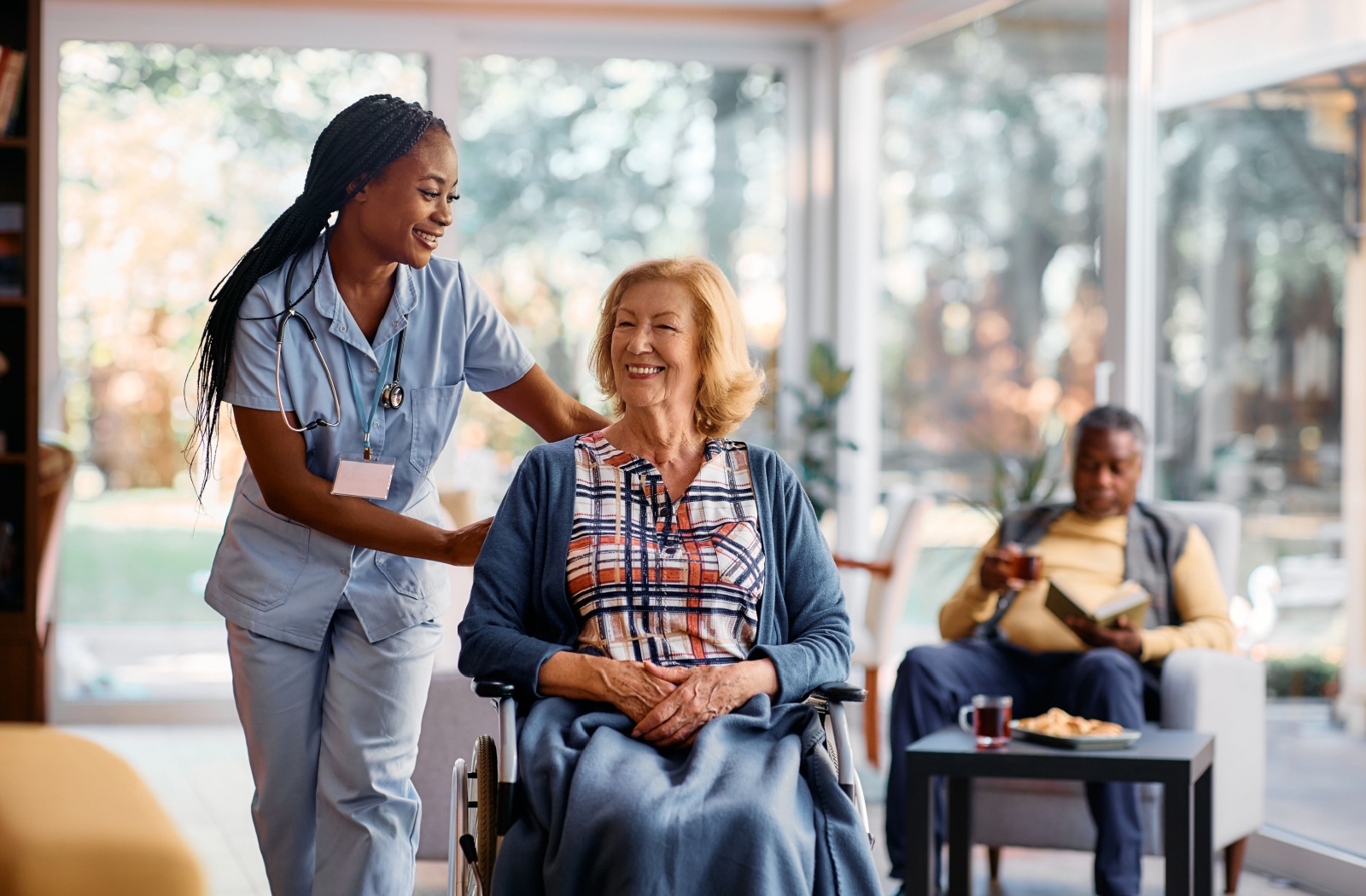 An assisted living staff member happily supporting a resident.